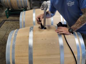 Man filling up a wine barrel